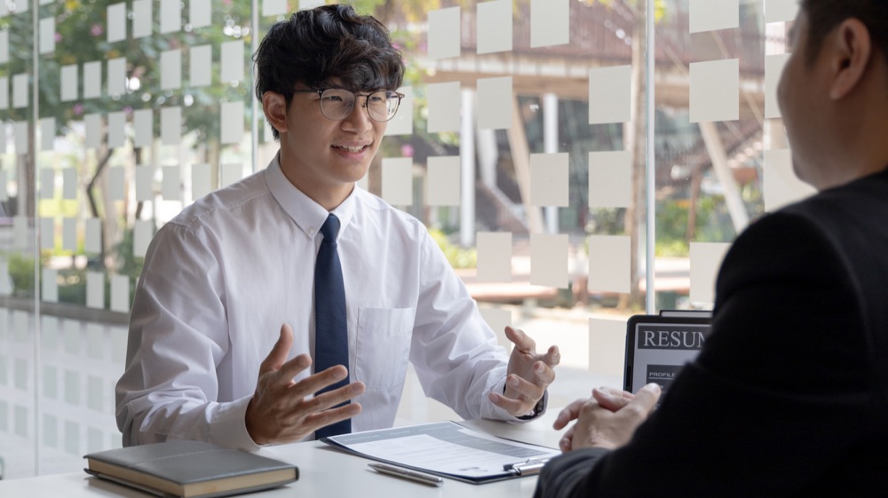 企業の担当者と話す若い男性